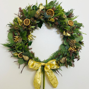 Christmas wreaths with seasonal foliage, cones, orange and cinnamon tied with a handmade bow