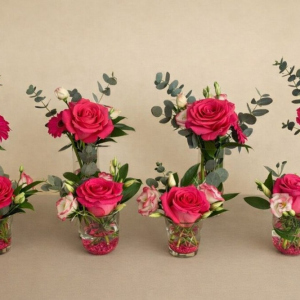 Milk bottle arrangement with Ecuadorian rose, Gerbera daisy, lisianthus and eucalyptus and decorative stones