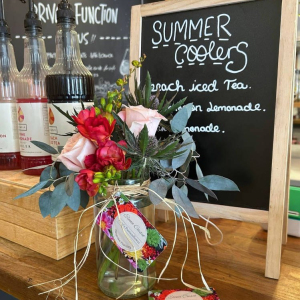 Jam jar arrangements with freesia, pink roses, thistle and eucalyptus