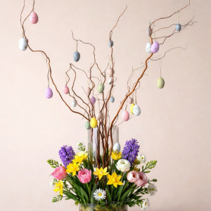 small flower arrangement in glass bottle with easter eggs
