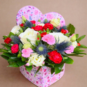 arrangement of different coloured flowers in pink box with pink heart