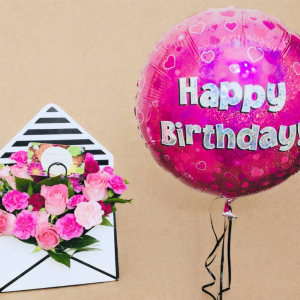 arrangement of light and dark pink roses with a pink balloon