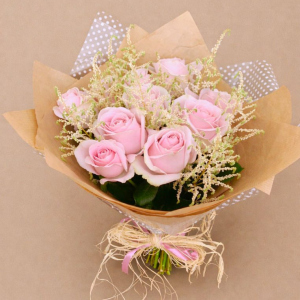 arrangement of pink roses sprinkled with green foliage