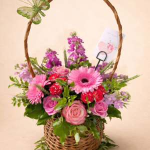 a beautiful basket display of Spring florals with a butterfly addition