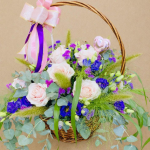 small basket of pink roses with smaller multicoloured flowers