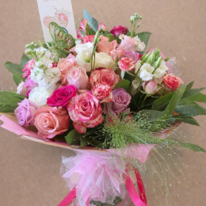 bouquet of pink, red and white roses tied with dark pink ribbon