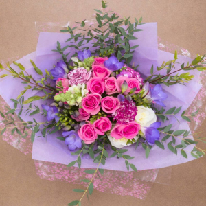 Posy with roses of many colours cushioned by green foliage