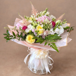 bouquet sporting multicoloured flowers tied with white ribbon