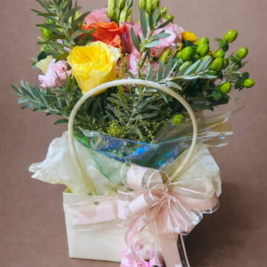 flower arrangement in small box tied with pink ribbon