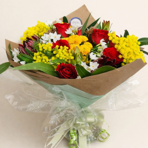 large posy with multicoloured flowers tied with cream bow