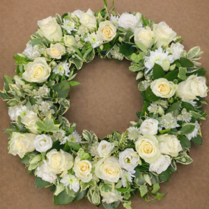 circular bed of white and yellow flowers on green foliage