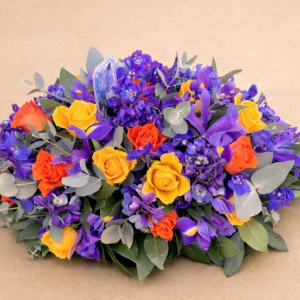 floral display with red and yellow roses in a bed of violet flowers