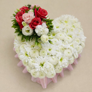 heart shaped array with white flowers and a bunch of multi-coloured flowers