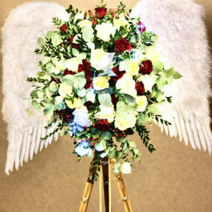white wings with multicoloured flowers on wooden stand