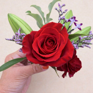 hand holding posy of red roses
