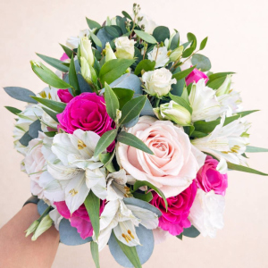 hand holding red pink white roses