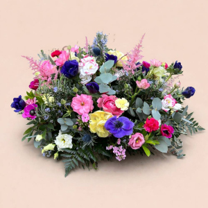 multicoloured flower arrangement on bed of green foliage