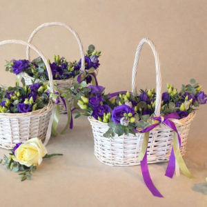 three baskets of multicoloured flowers and purple ribbon