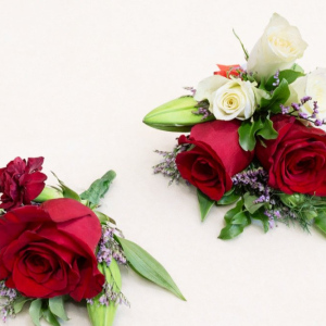 two posies of red roses wrapped with green foliage