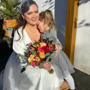 woman holding multi-coloured posy and cuddling a young child